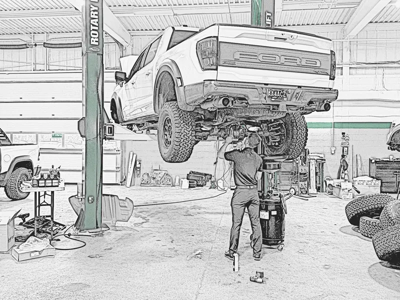 Graphite sketch of a technician working beneath a raised Ford Raptor in a service bay.
